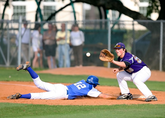 two baseball players one sliding back to first base