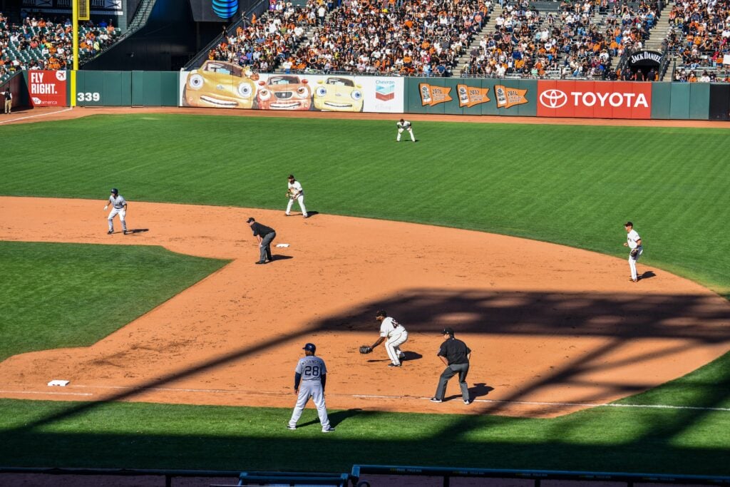 a baseball game with base runners and a team fielding